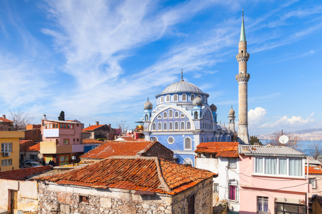 Street view with old living houses and Fatih Camii (Esrefpasa) old mosque, Izmir, Turkey